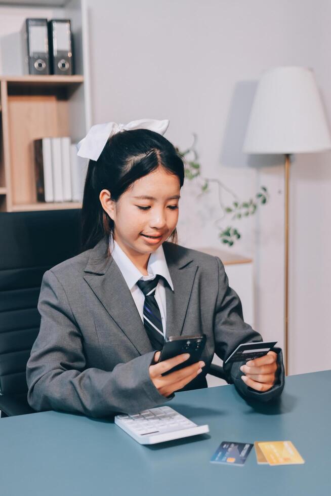 Asian girl in business suit using her phone photo