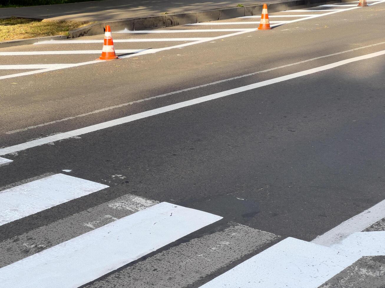 Traffic cones indicate ongoing road work at a pedestrian crossing, enhancing safety in the urban environment under bright sunlight photo