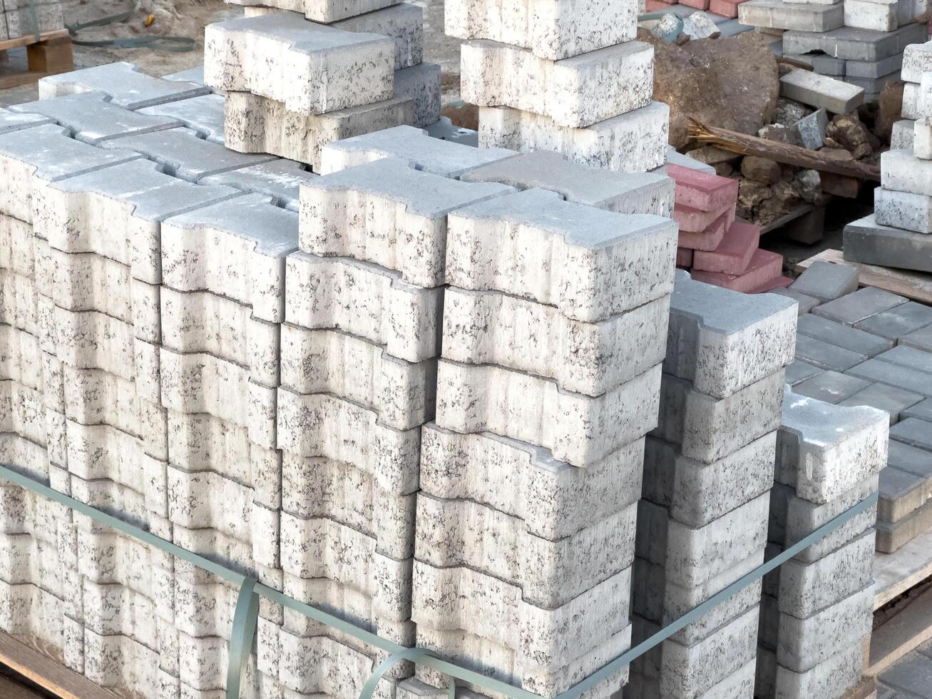 Pallets of gray concrete blocks arranged orderly in a construction area under natural light, showcasing preparation for masonry work photo