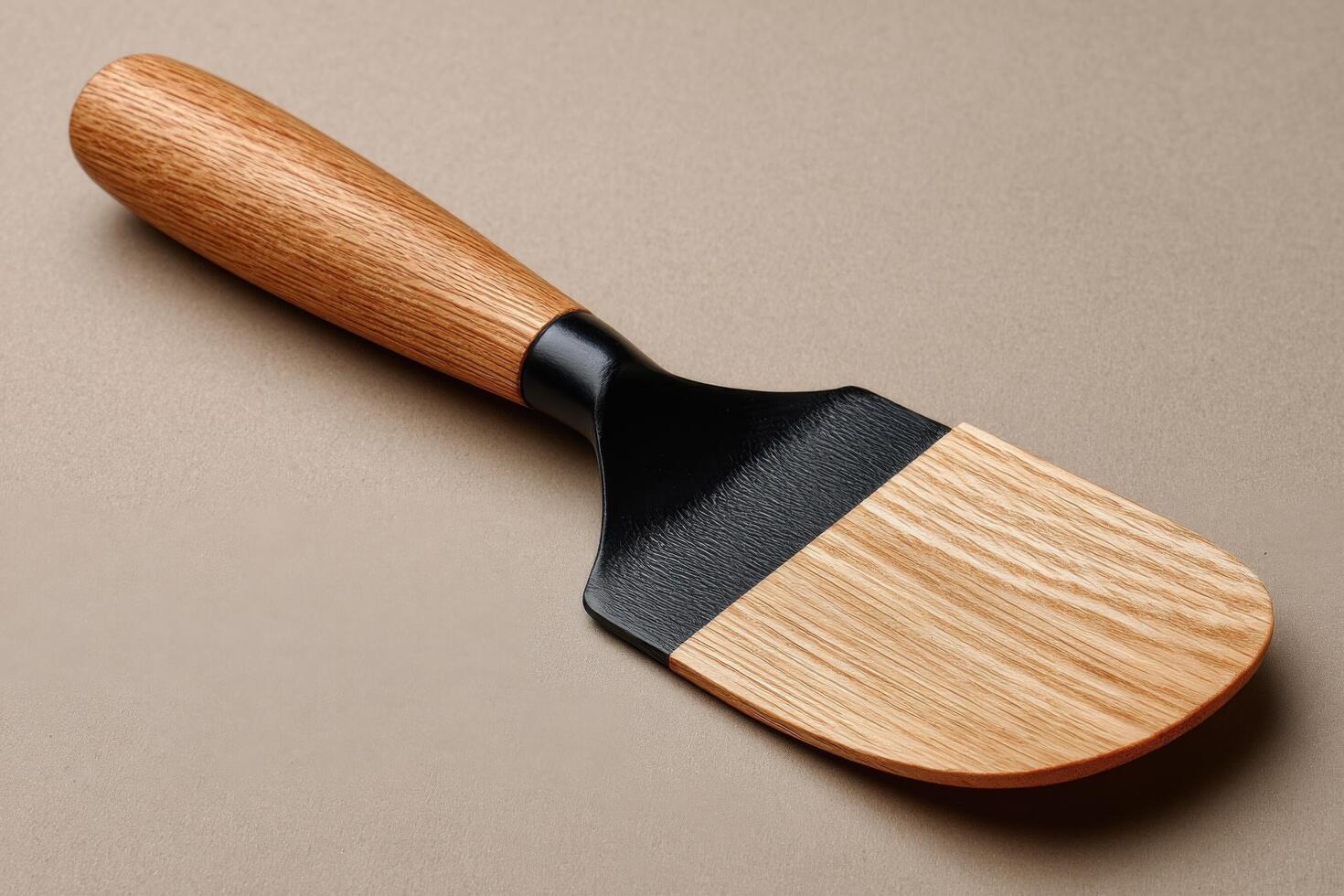A wooden spatula with a black handle photo