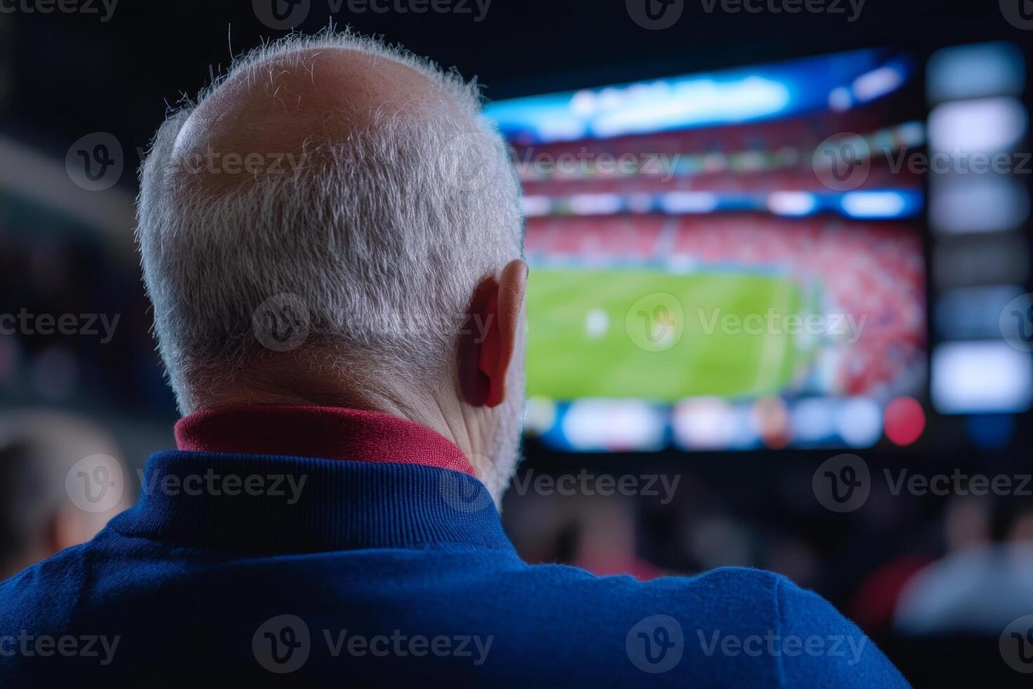 Elderly man watching sports on large screen in bar, enjoying the excitement of the match with friends photo