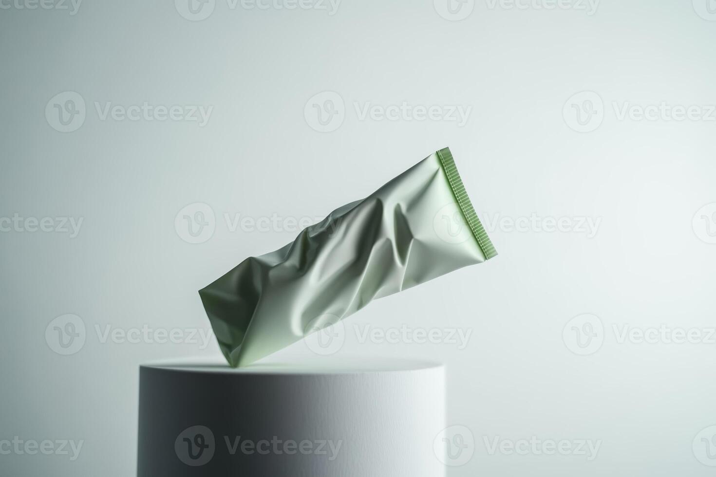Crumpled green packaging floating above a white pedestal in studio lighting, depicting innovative product design and sustainability concepts photo