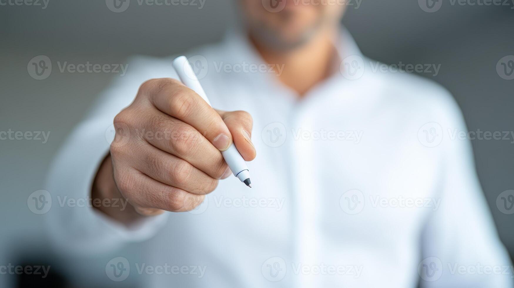 Business professional holding a pen ready to sign documents in a modern office environment during the workday photo