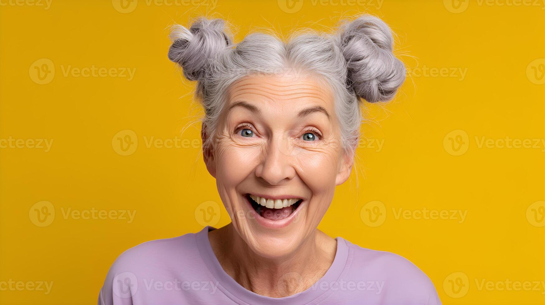 Portrait of surprised senior woman showing excitement on yellow background photo