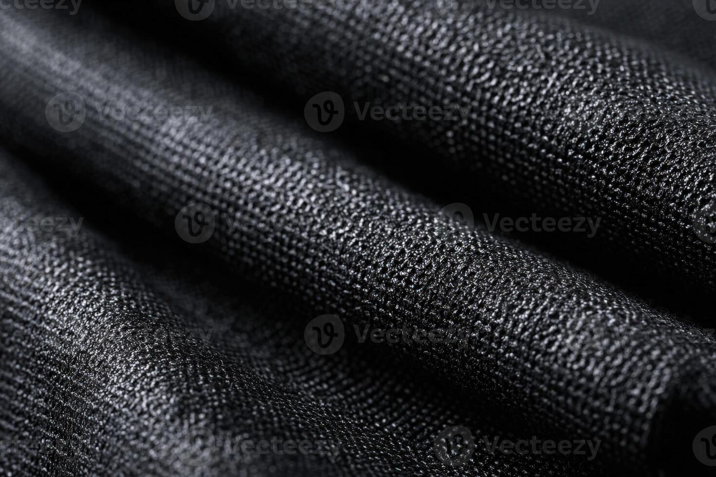 Deep black Kevlar weave fabric displaying subtle texture and intricate patterns in natural light photo