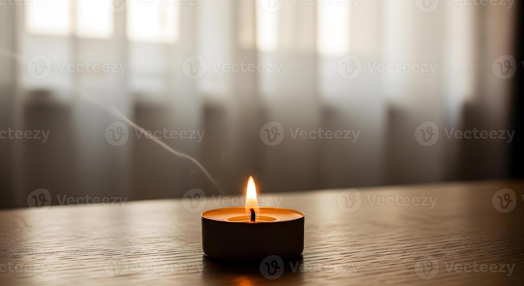 A single candle is lit on a table photo