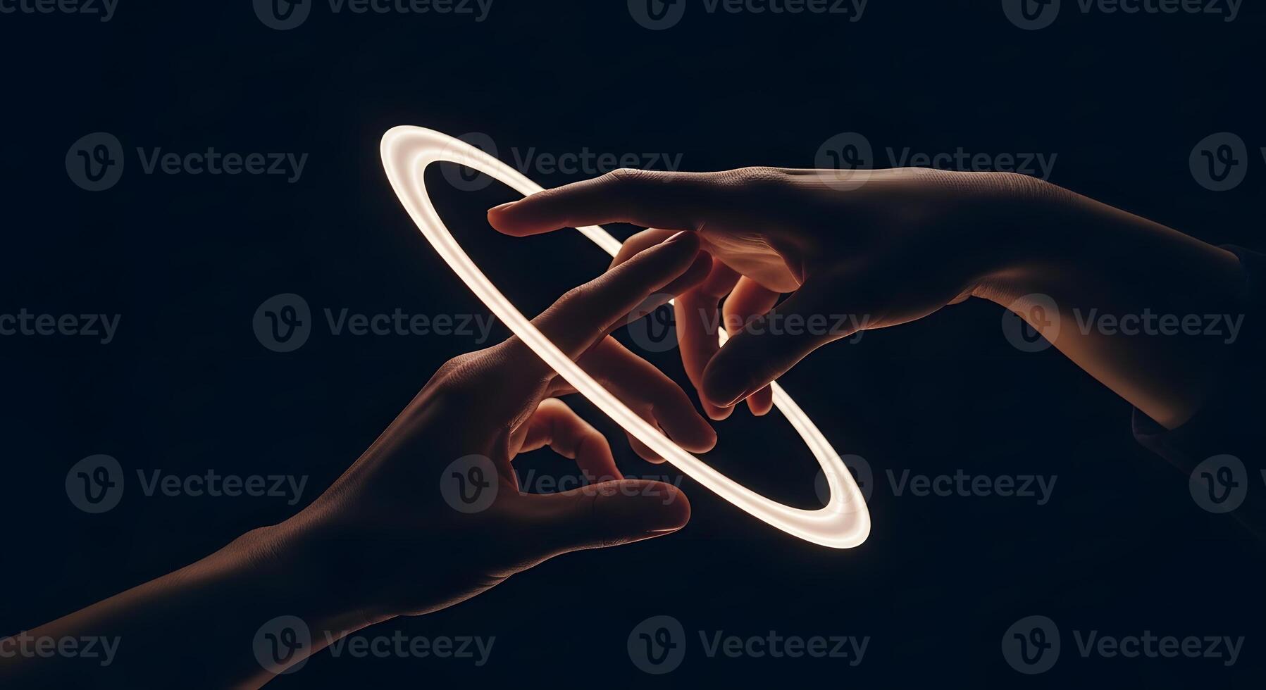 Two hands holding a ring in front of a black background photo