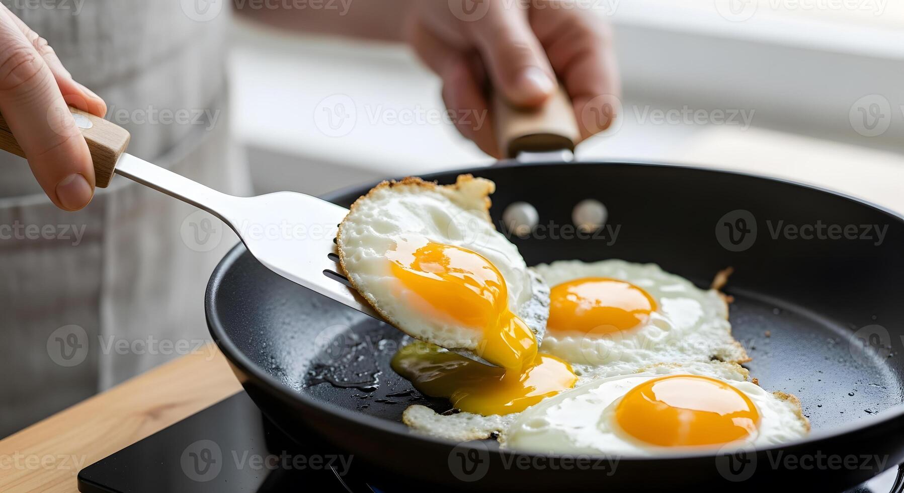 A person is frying two eggs in a pan photo