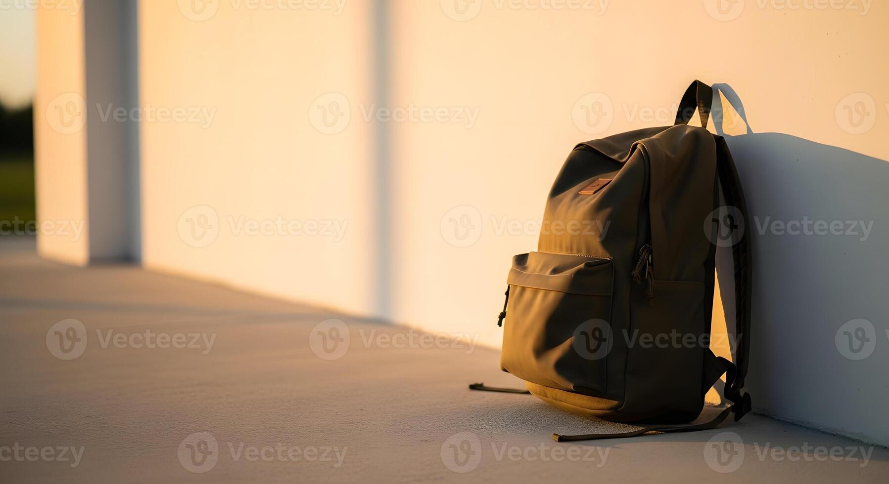 A backpack sitting on the ground near a wall photo