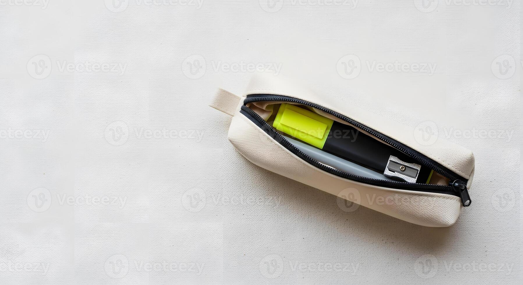 A white zipper pouch with a pen and a yellow marker photo