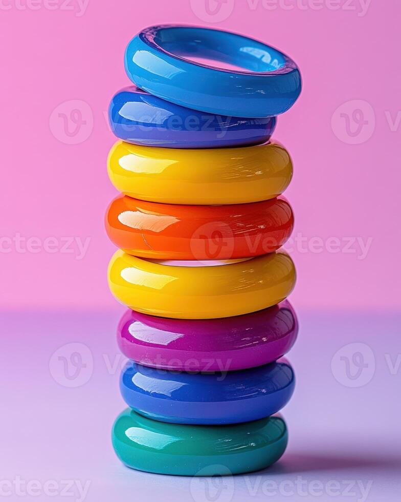 A stack of colorful rings on a pink background photo