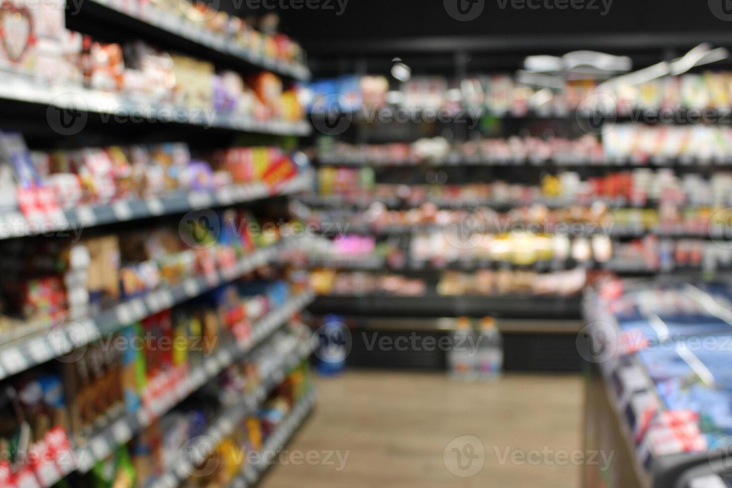 Blurred photo of racks of goods and freezers in a small grocery store