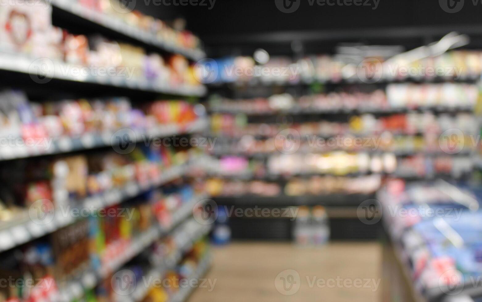 Shelves and stands full of products in a grocery store defocused view stock photo