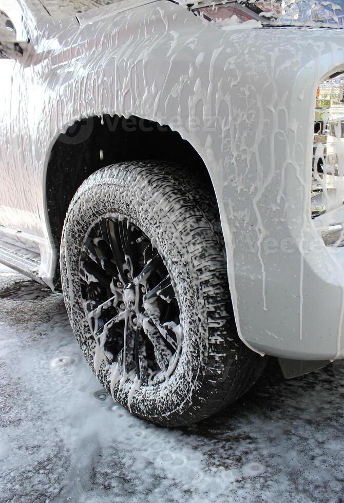 Washing Foam On A Front Wheel Of Vehicle photo