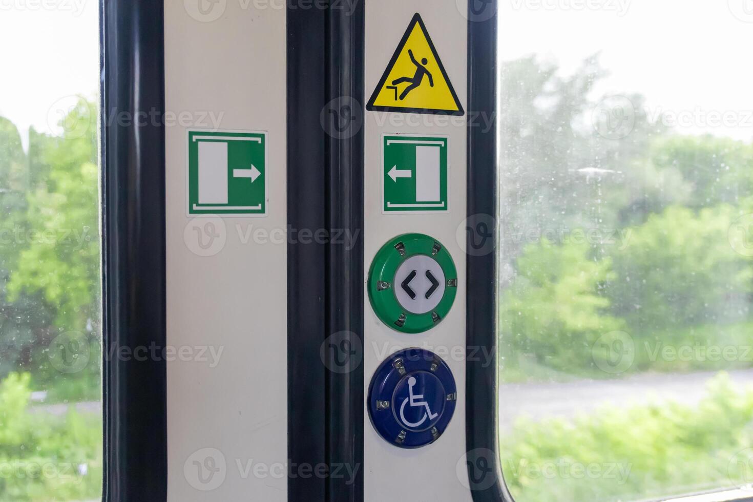 Train door panel with essential safety warning signs, clear exit arrows, and passenger assistance buttons for public transportation access and guidance photo