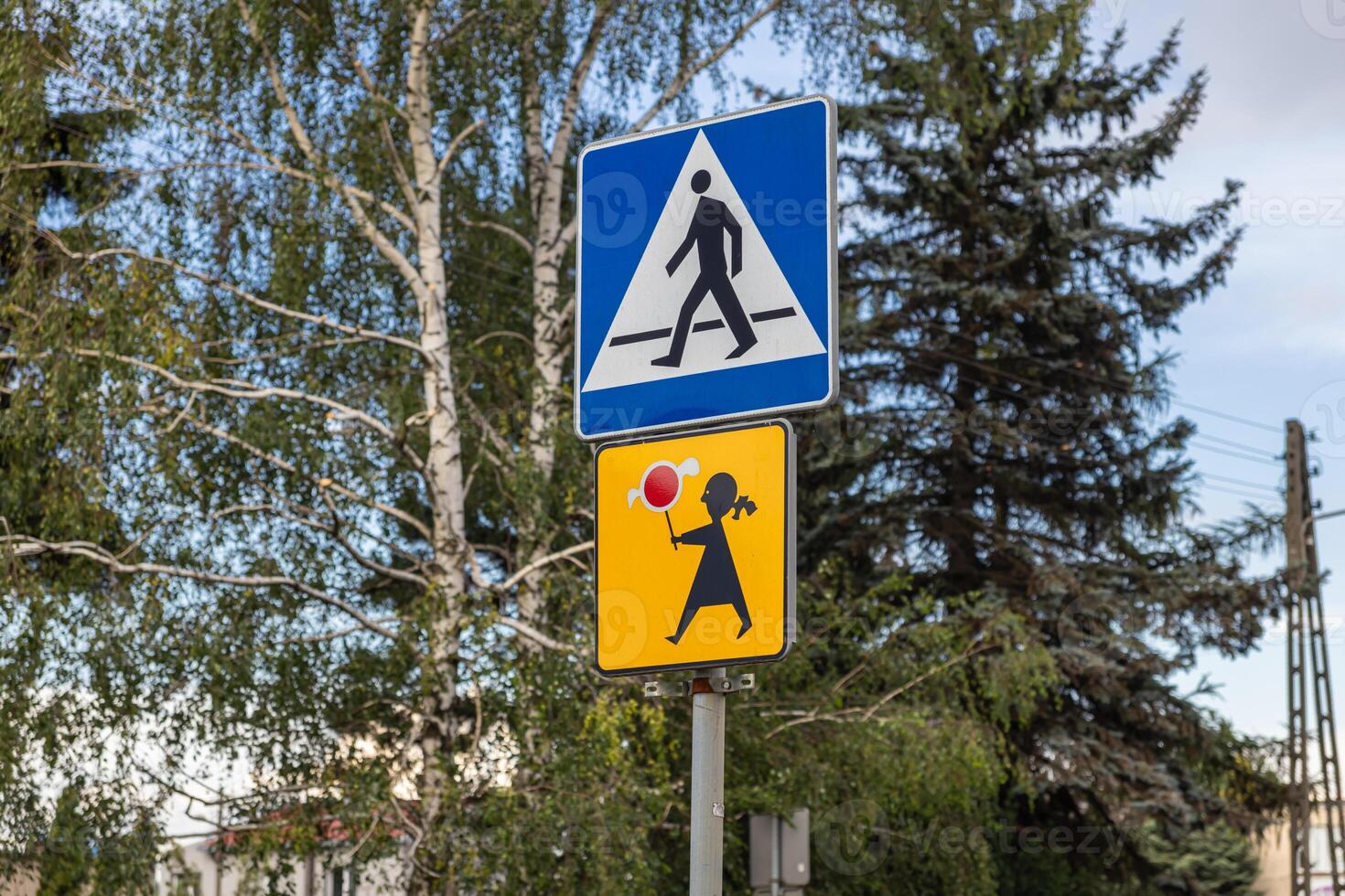 Prominent road signs displaying pedestrian crossing and child safety symbols, promoting crucial awareness and caution for drivers in an urban environment photo