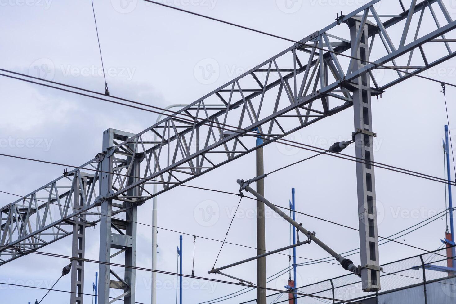 Overhead railway electrification system featuring intricate power lines and robust metal support structures, vital for urban transport infrastructure development photo
