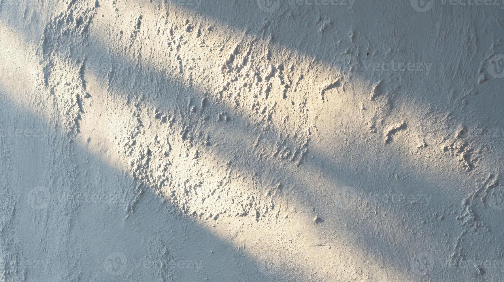 Rough white wall texture illuminated by warm sunlight and dark shadows. photo