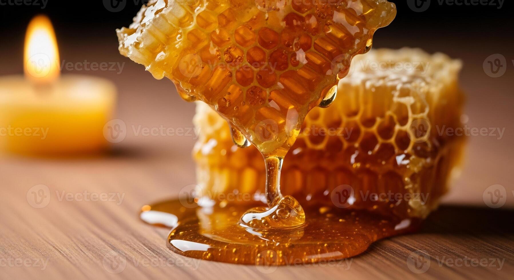 Natural honey flowing from beeswax comb, illuminated by warm candlelight. photo