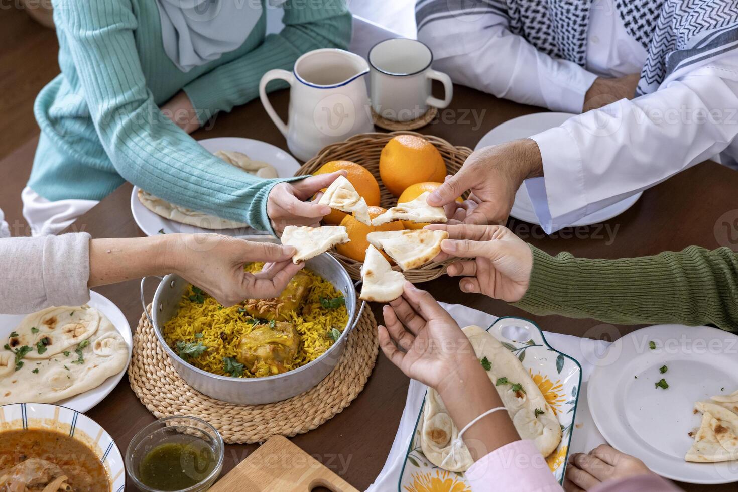 Close up of people hands sharing slice pieces of naan bread together in a dinner with friend and family gathering for seasonal feast and celebration festival in Middle east and Indian culture photo