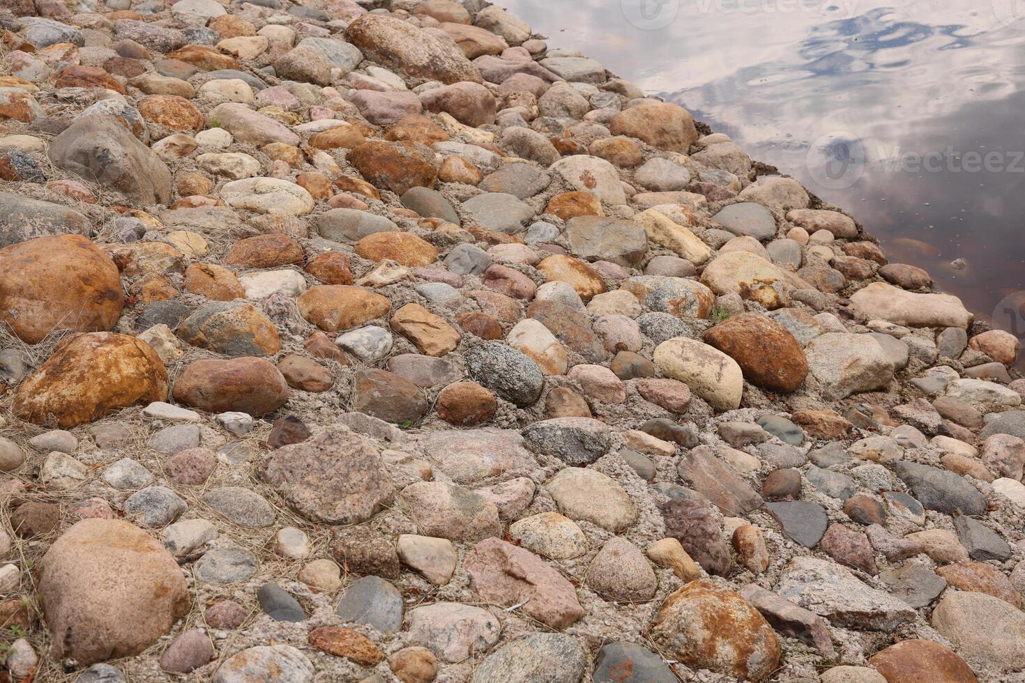 Pebbly Shoreline by Calm Water a picturesque scene that embodies relaxation and tranquility photo