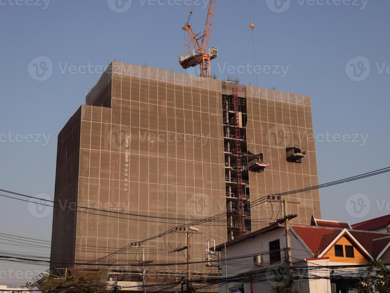 An Urban Construction Site Featuring a Crane and a Structure That is Currently Rising Upwards photo