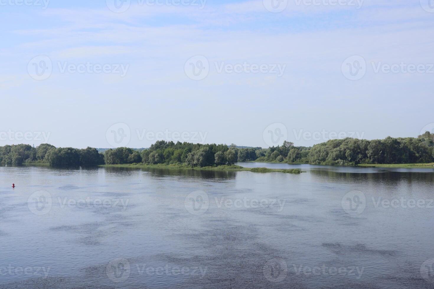 The Serene and Tranquil River Landscape Under a Clear and Vibrant Blue Sky Above photo