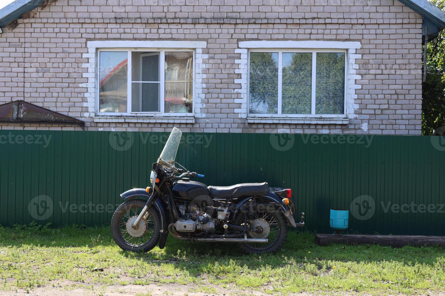 A classic motorcycle parked by a rustic house, capturing nostalgia and adventure photo