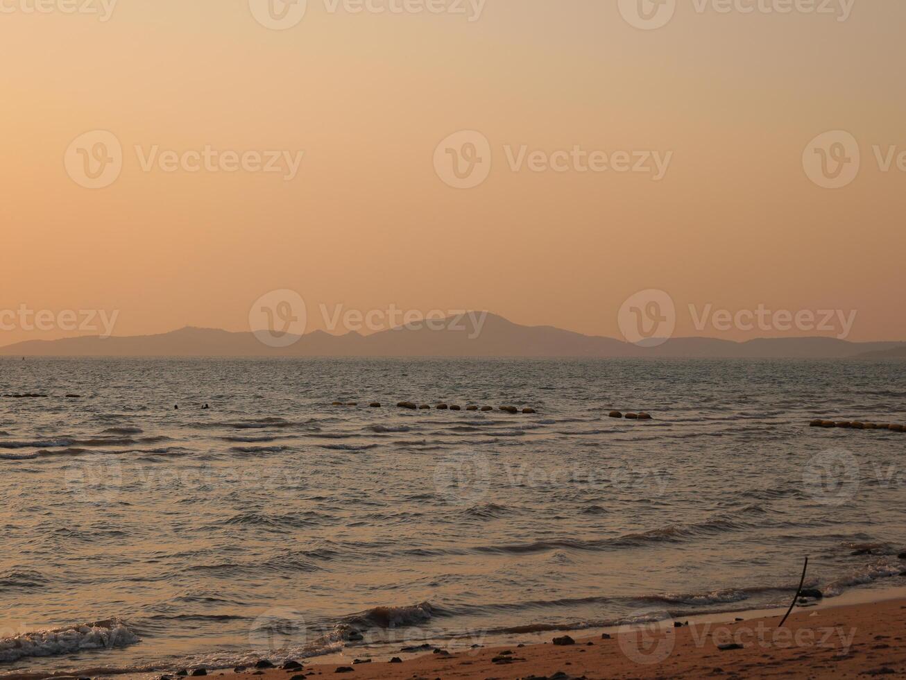 Enjoy the beautiful serene beach sunset casting vibrant hues over calm, reflective waters photo