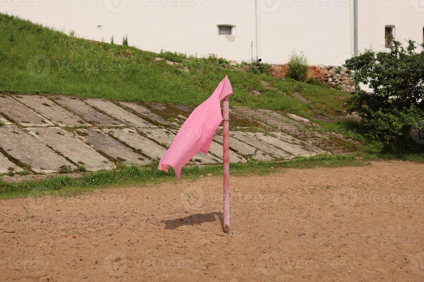 A striking Pink Flag placed on a Sandy Ground surrounded by the beauty of Nature photo