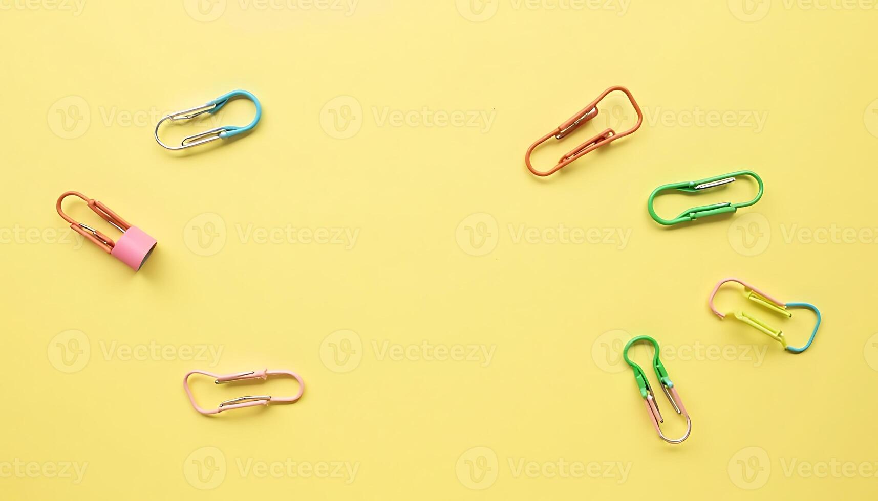 Colorful Paper Clips on Yellow Background Flat Lay photo