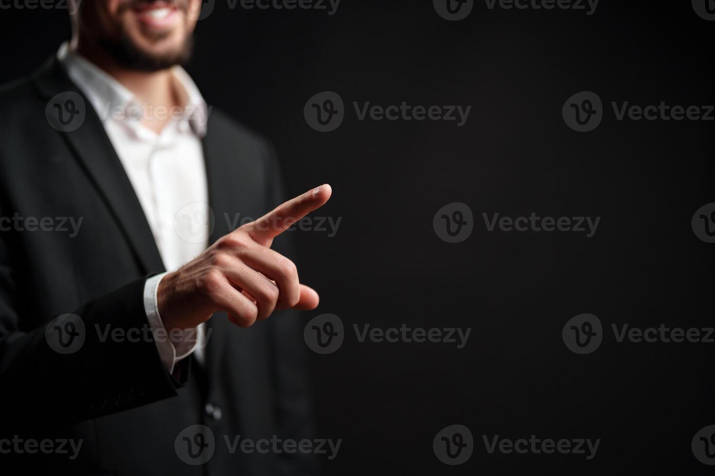 Businessman gesturing positively during a corporate presentation in a dark studio setting photo