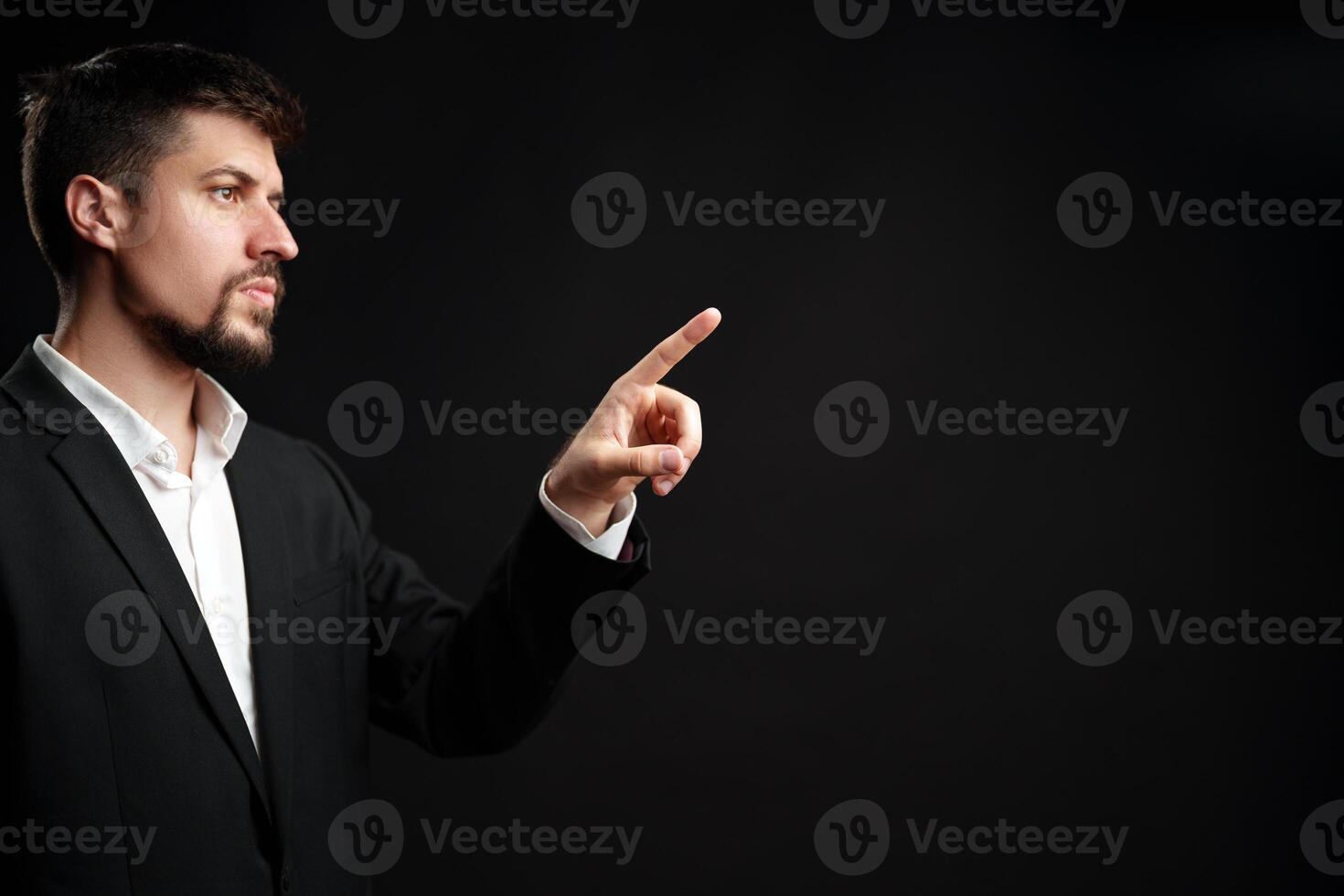 Business professional gestures confidently while presenting an idea in a formal setting against a dark background photo