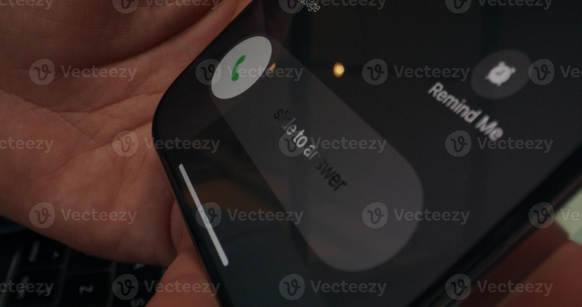 A person holding a cell phone with the call button on it photo