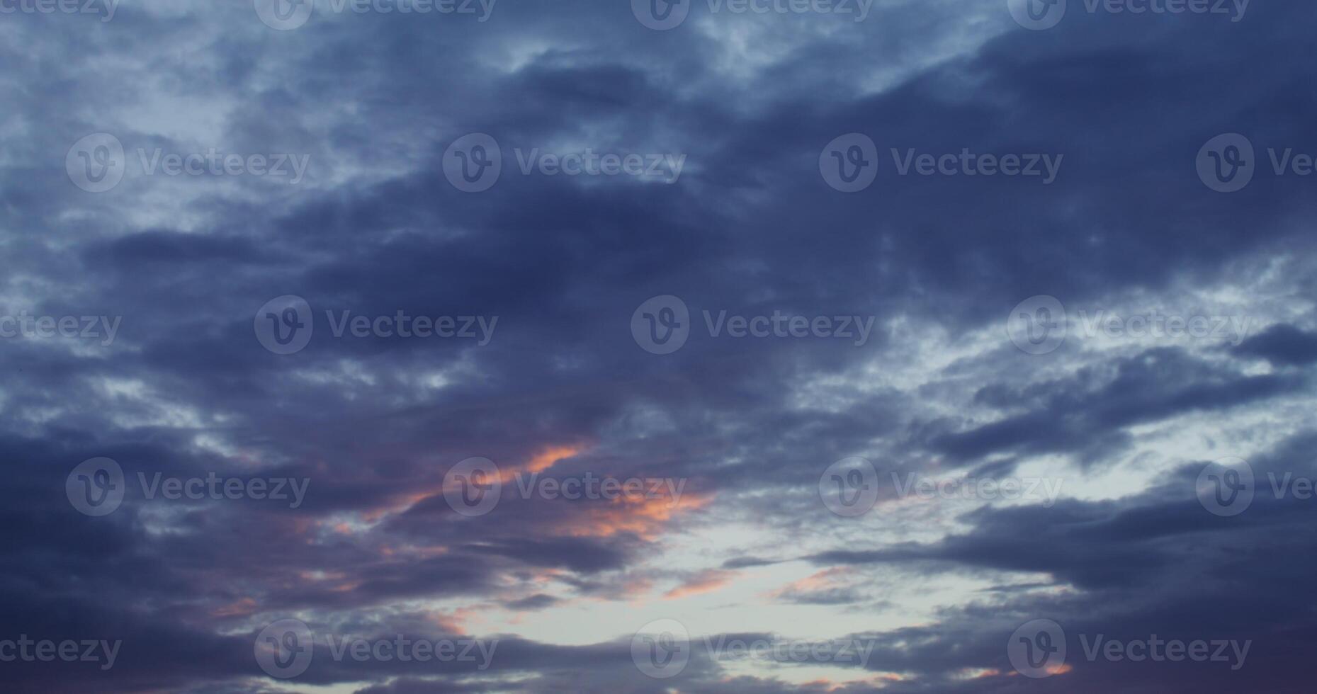 A sunset over a field with a few clouds photo
