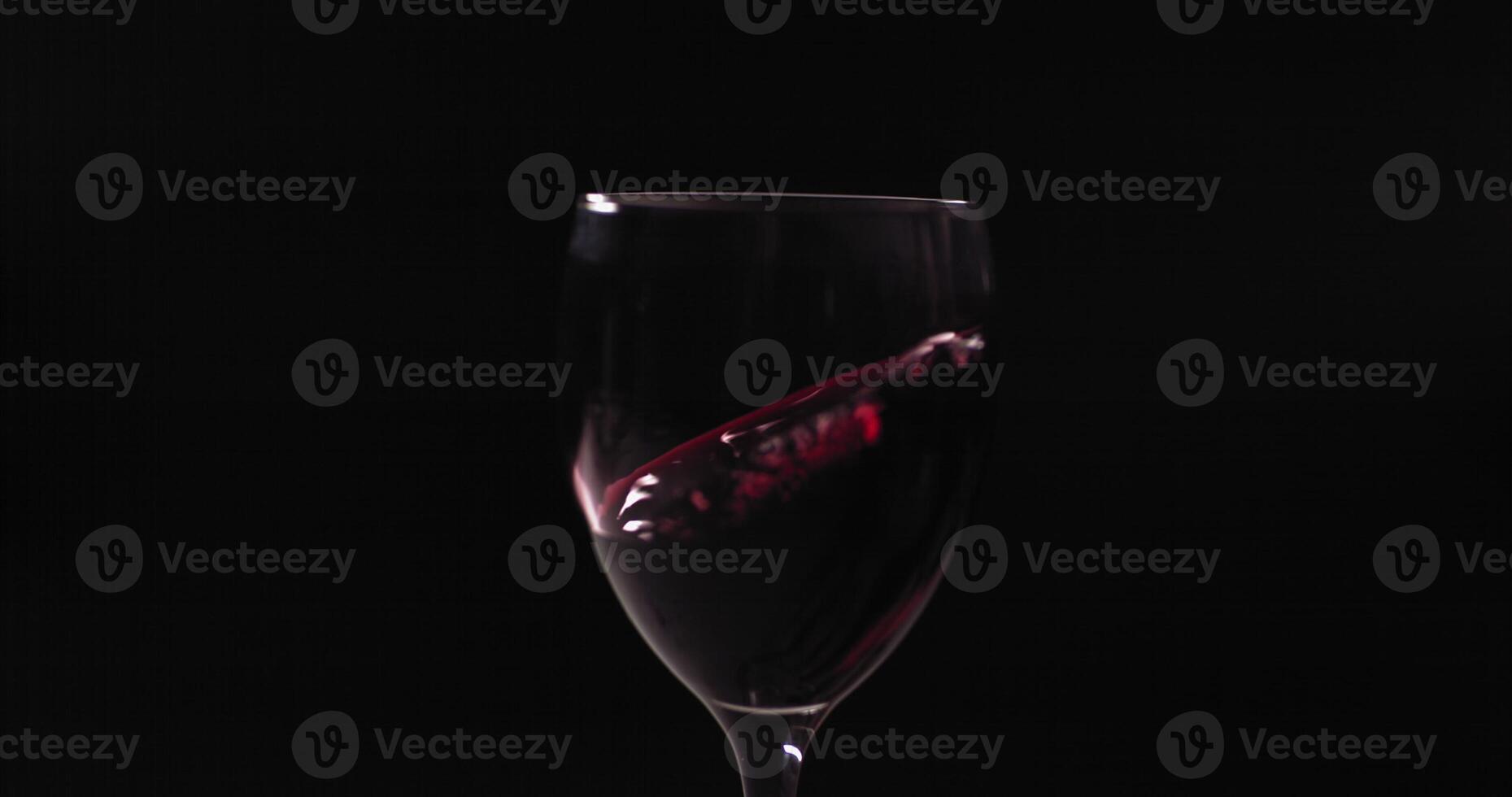 A wine glass with a red liquid in it photo