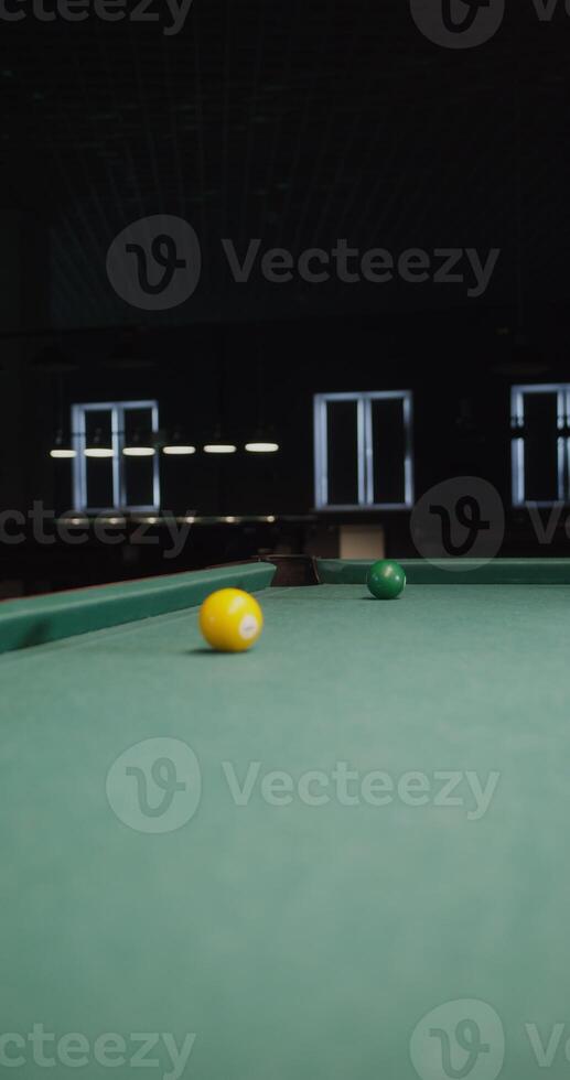 A pool table with a green cloth and a yellow ball photo
