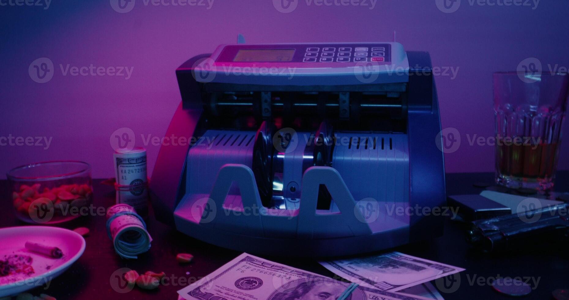 A money counting machine and a glass of alcohol photo