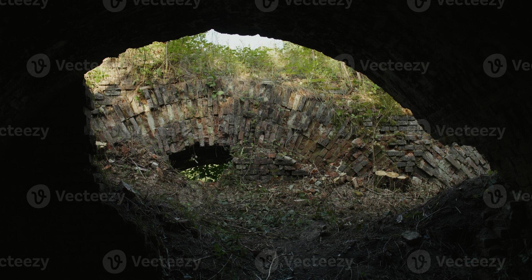 An old tunnel with a light coming from it photo