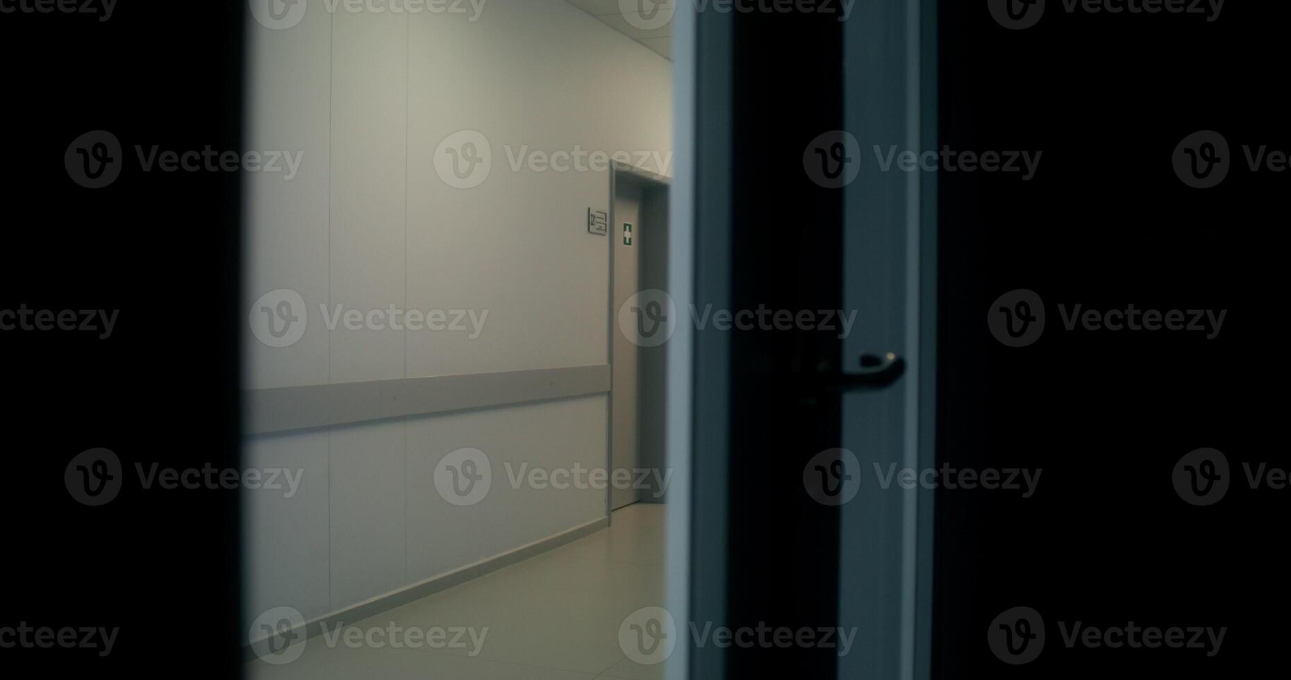 A hallway with a door open and a light on photo