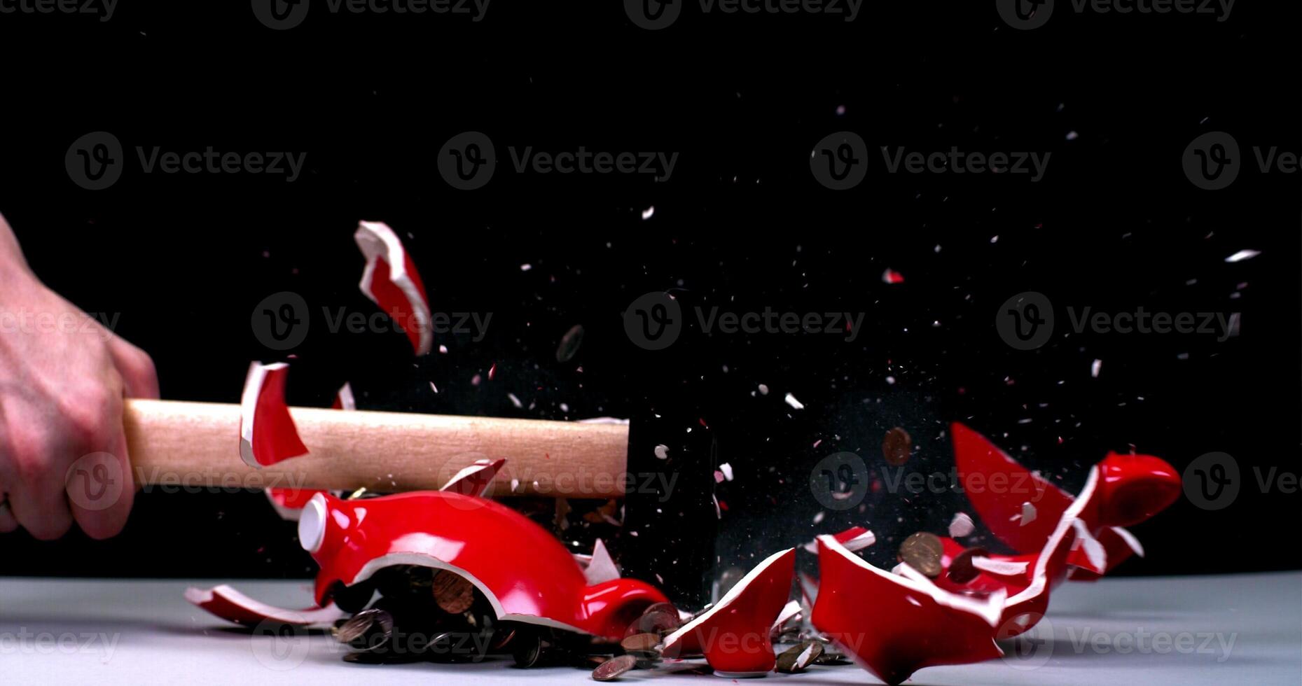 A person is smashing a red object with a wooden stick photo