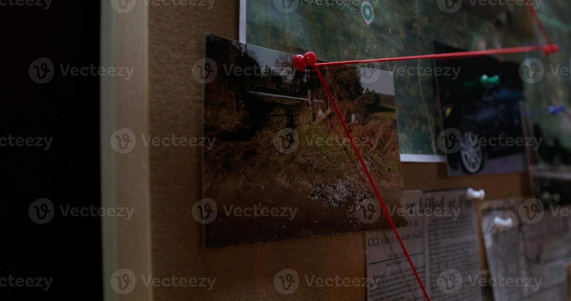 A red string attached to a bulletin board photo