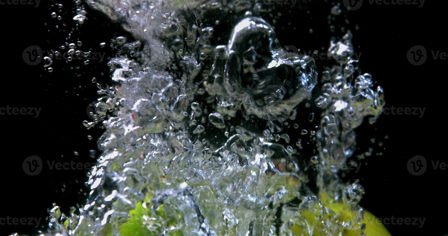A green apple being splashed with water photo