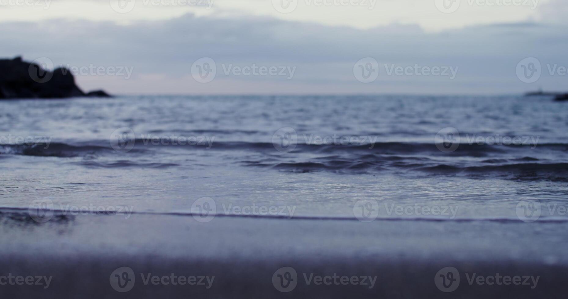 A person standing on a beach with a surfboard photo