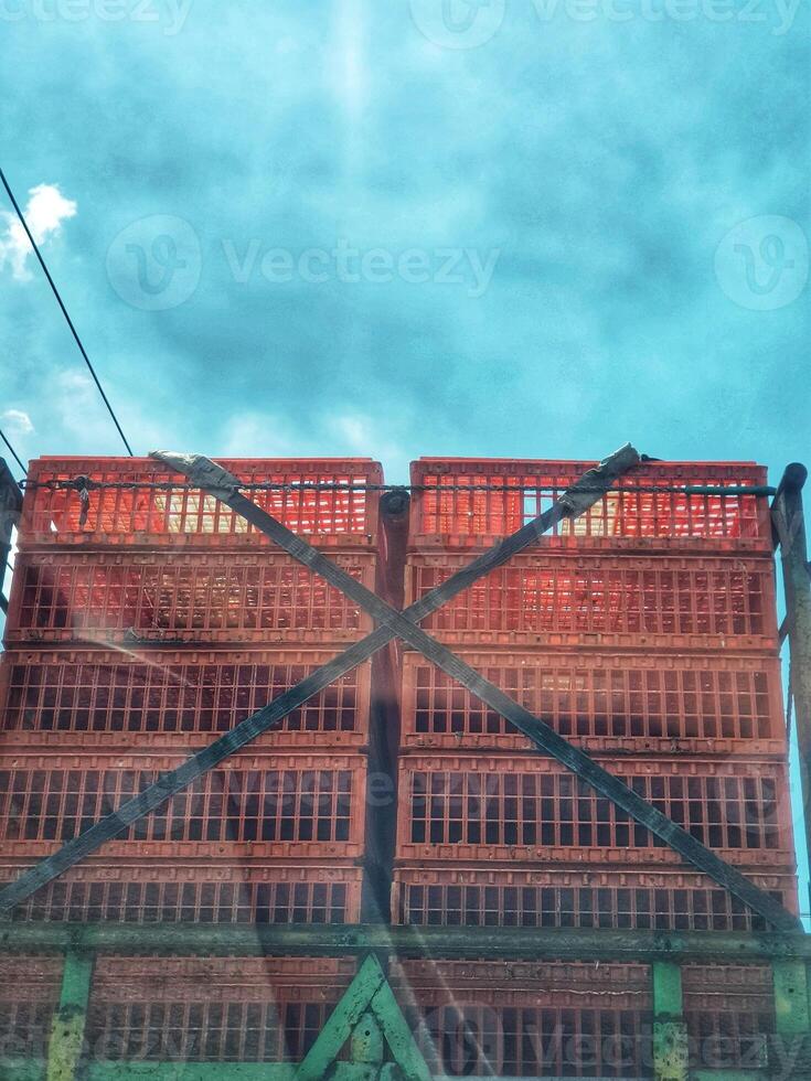 Stacked Plastic Crates on Truck Under Sunny Blue Sky for Transport photo