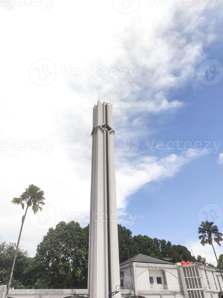 A low-angle shot of the white mosque tower. The minarets surrounding the mosque serve to broadcast the call to prayer for Muslims. Mosque architecture with negative space. photo