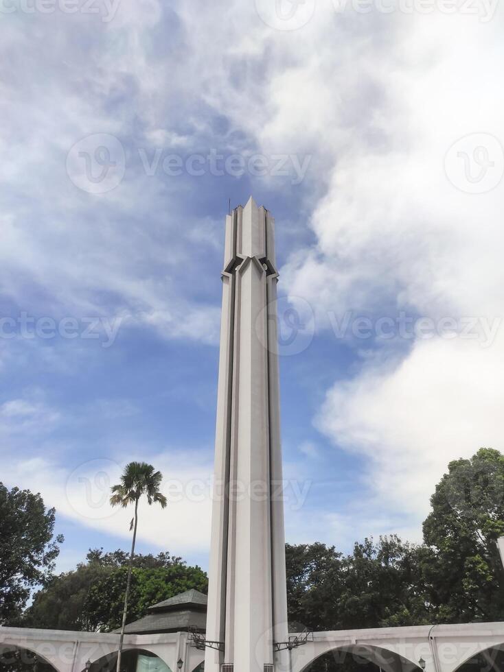 A low-angle shot of the white mosque tower. The minarets surrounding the mosque serve to broadcast the call to prayer for Muslims. Mosque architecture with text space. photo