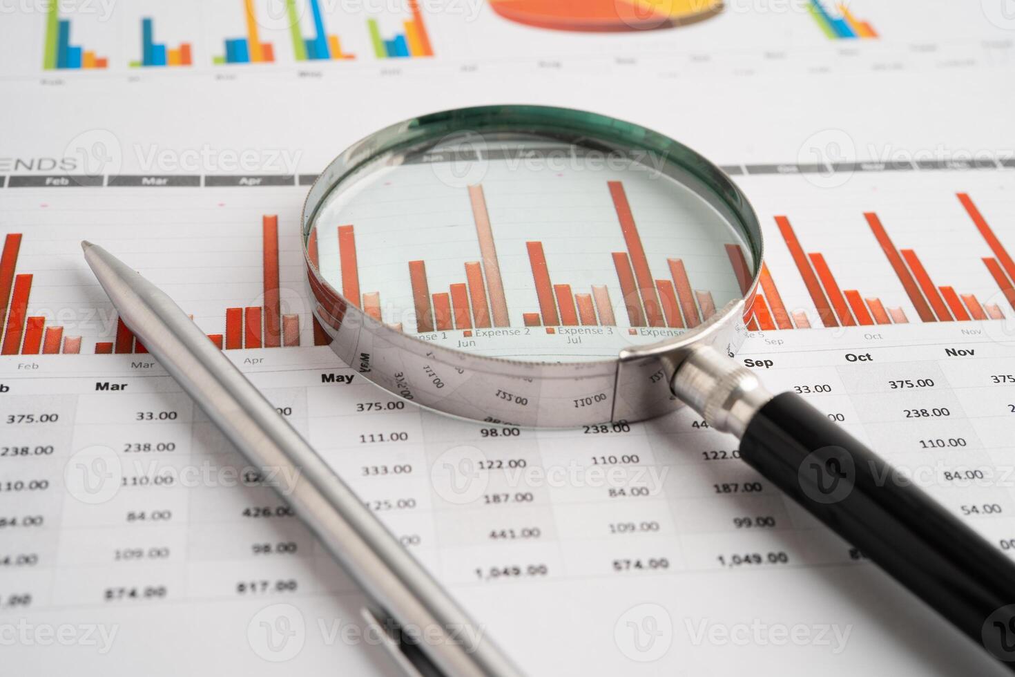 Magnifying glass spreadsheet and graph paper. photo