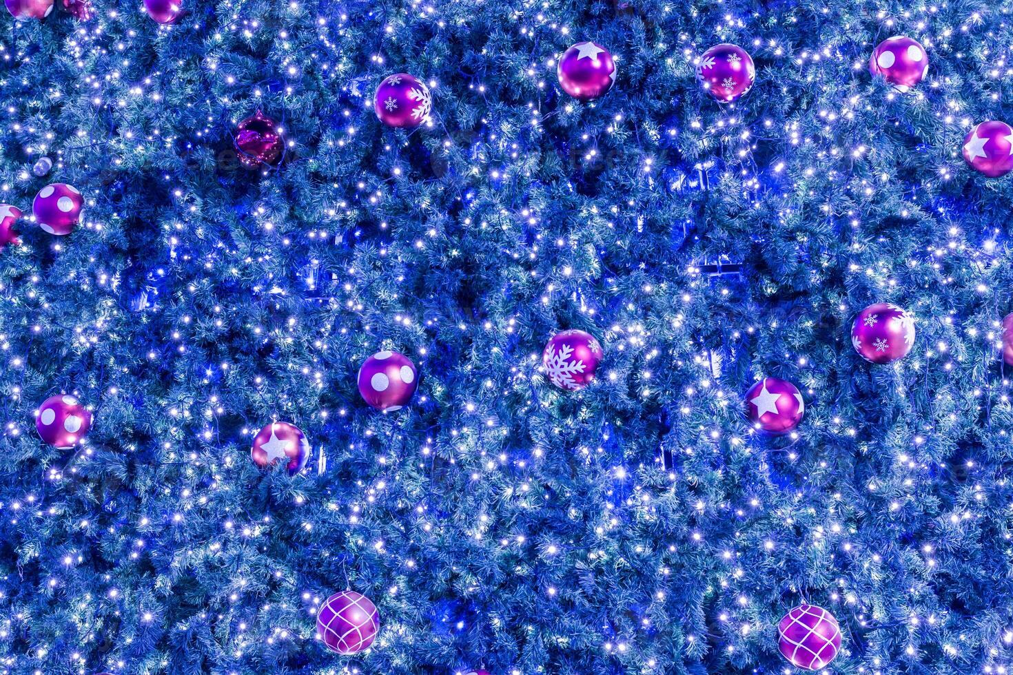 A blue christmas tree with pink balls and lights photo