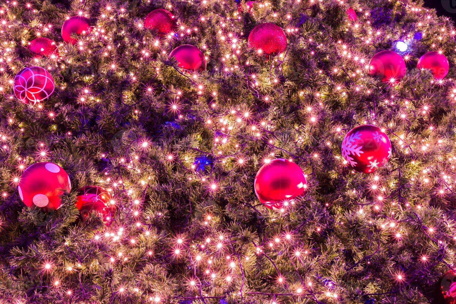 A large christmas tree with many red and pink balls photo